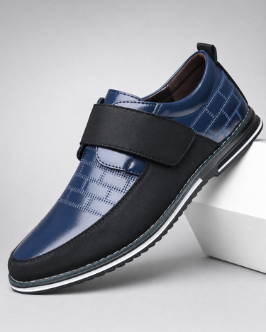 Blue and black shoe with a strap on a light gray background