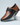Brown and black shoe with a strap on a light gray background