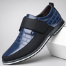Blue and black shoe with a strap on a light gray background