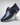 Blue and black shoe with a strap on a light gray background